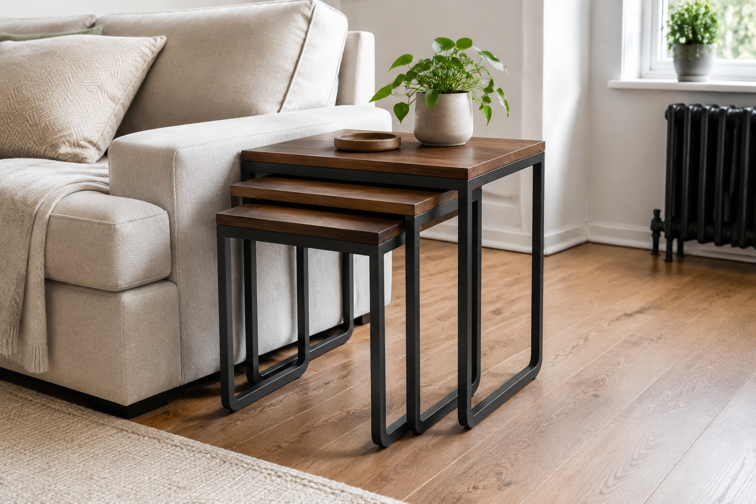 Three unbranded wood-top nesting tables with black metal legs partially nested beside a neutral sofa in a compact living room