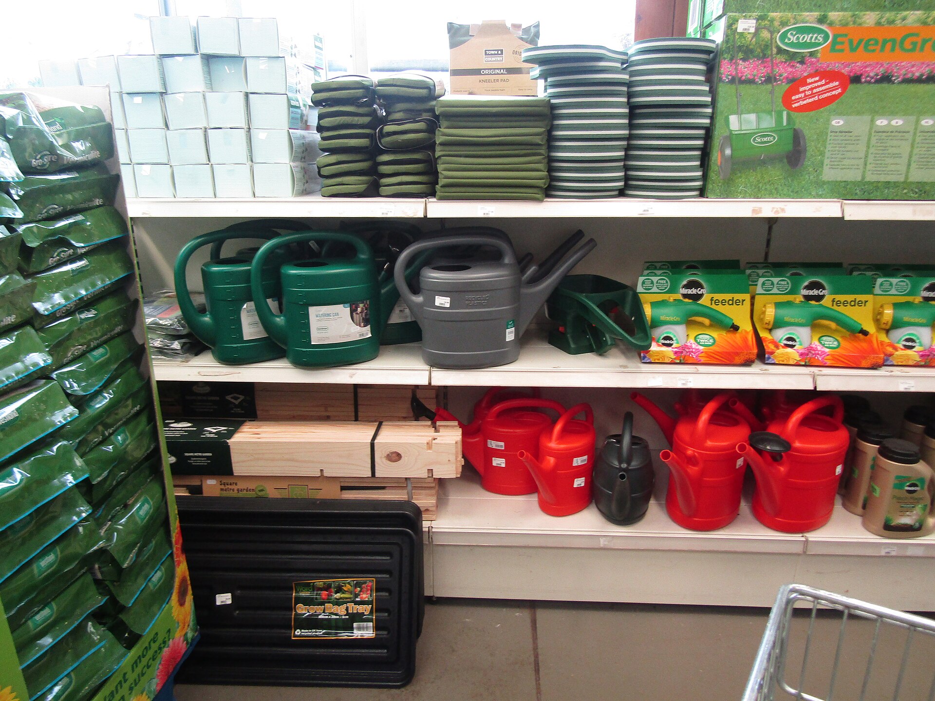 Assortment of real compact plastic watering cans showing different body, handle, spout, and fill-opening shapes